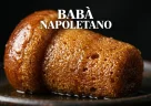 Babà napoletano imbevuto di sciroppo con consistenza soffice e superficie lucida in primo piano