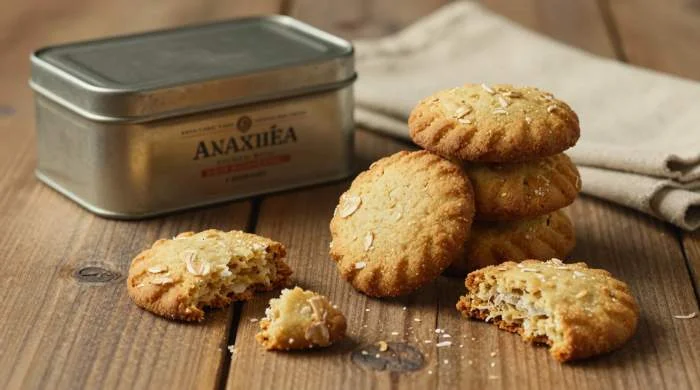 Biscotti Anzac serviti su tavolo con scatola di latta vintage
