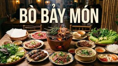Bò Bảy Món vietnamita con sette preparazioni di manzo disposte attorno a una griglia a carbone con erbe fresche e carta di riso