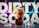 Dirty soda cremosa con strati colorati servita in un bicchiere moderno