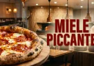 Pizza contemporanea con miele piccante al peperoncino versato su mozzarella salame e cornicione