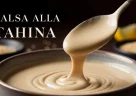 Salsa tahina cremosa servita in una ciotola con illuminazione drammatica