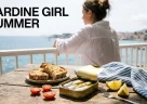 Sardine in scatola con olio d'oliva pane tostato limone e pomodori in una scena estiva mediterranea