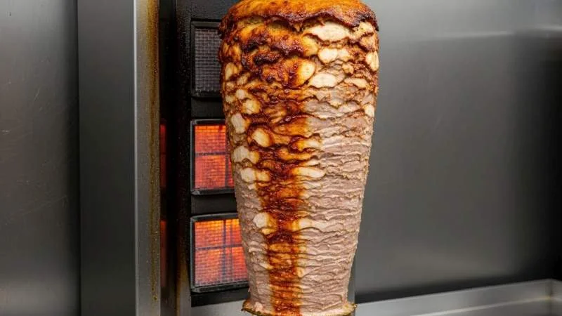 Shawarma cotto sullo spiedo verticale con carne marinata e pane pita