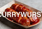 Currywurst berlinese con salsiccia affettata ricoperta di ketchup e curry