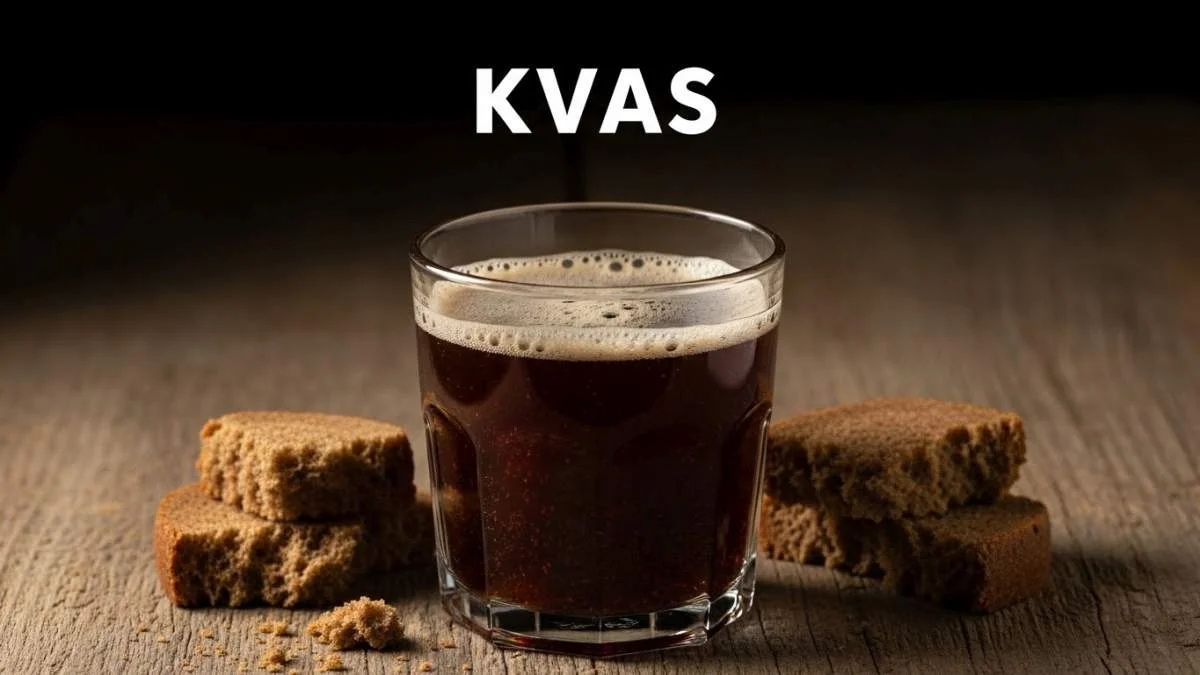 Kvas tradizionale versato in un bicchiere rustico accanto a pane nero