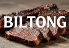 Biltong sudafricano essiccato tagliato a strisce su tagliere rustico