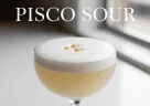 Pisco sour servito con schiuma cremosa e fetta di lime fresco
