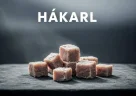 Cubetti di hákarl, squalo fermentato islandese, serviti su un piatto tradizionale nordico con stuzzicadenti