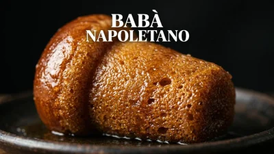 Babà napoletano imbevuto di sciroppo con consistenza soffice e superficie lucida in primo piano
